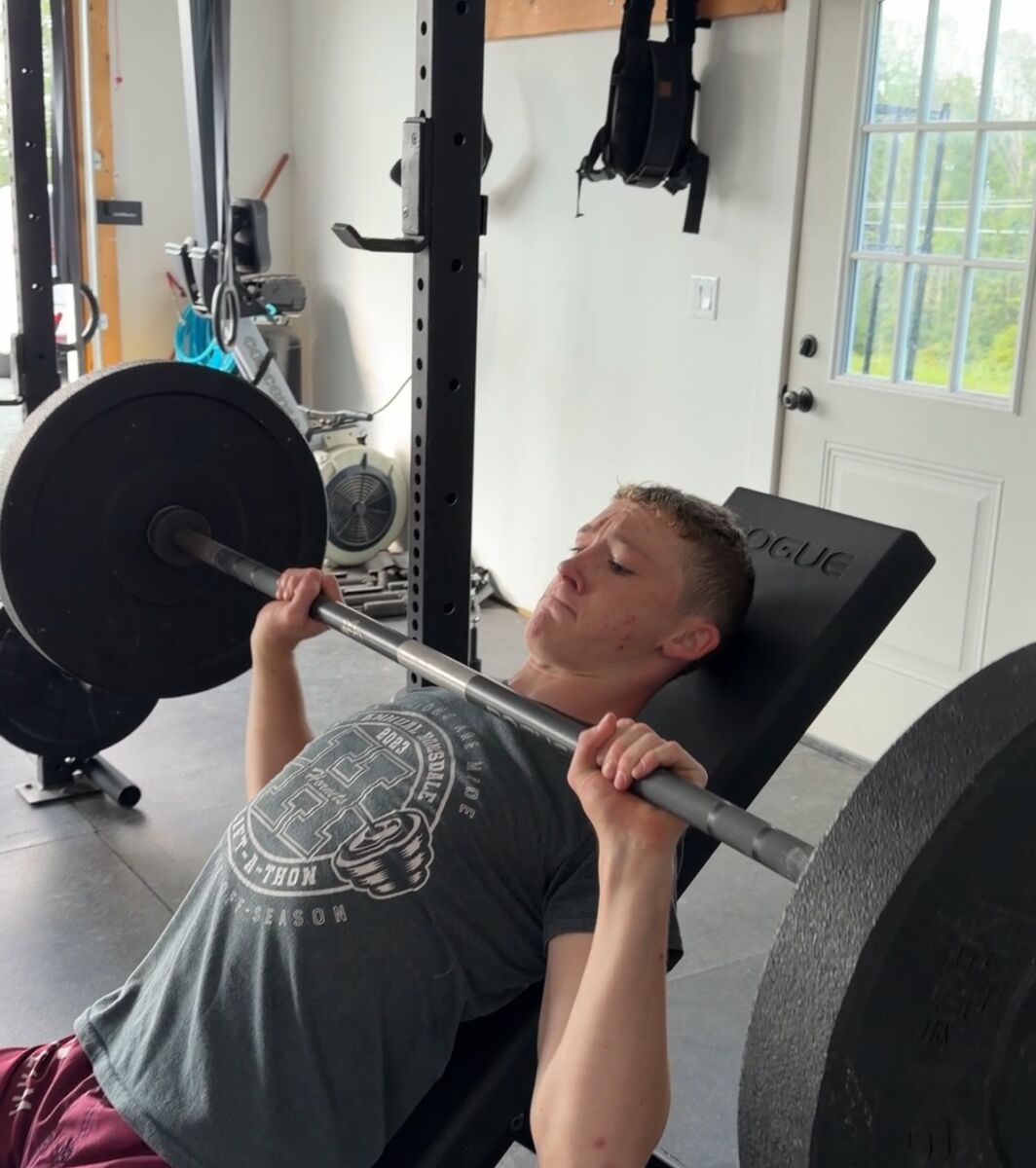 A high school athlete pressing on the incline bench